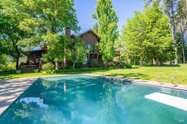 a view of a house with swimming pool and a yard
