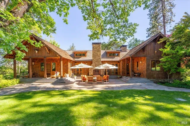 a view of a house with a big yard and large trees