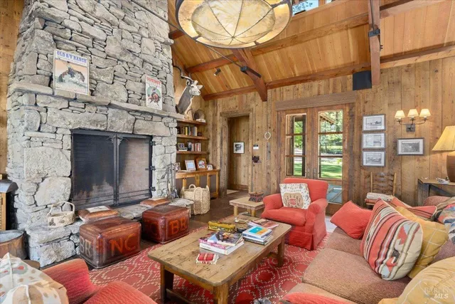 a living room with furniture a fireplace and a floor to ceiling window