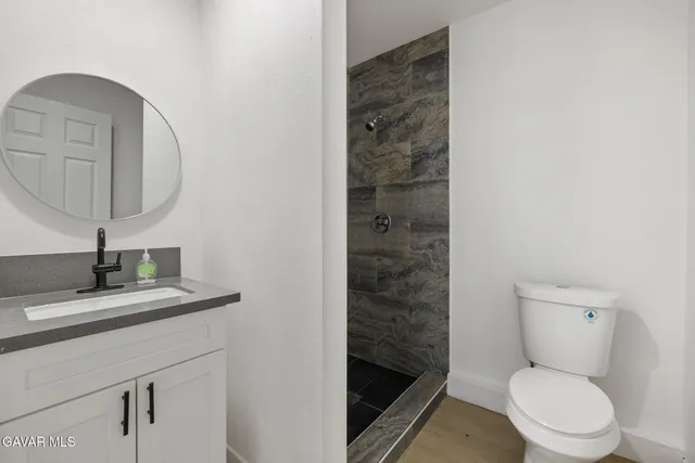 a bathroom with a toilet a sink and mirror