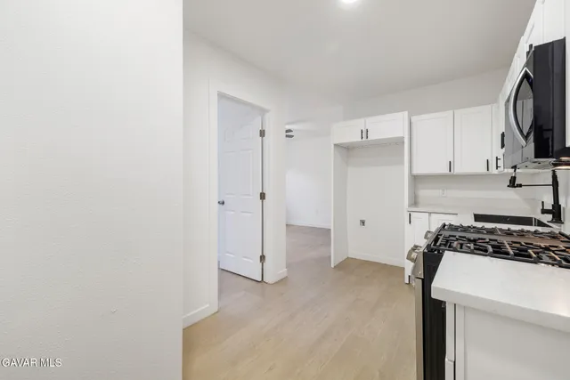a kitchen with a refrigerator and a stove top oven