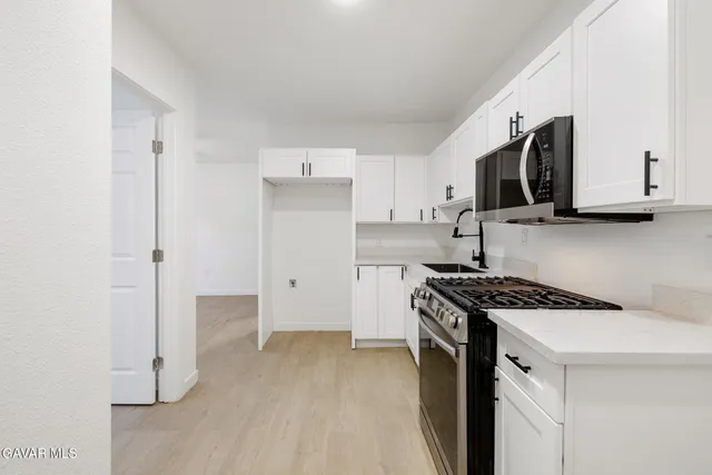 a kitchen with stainless steel appliances white cabinets and a stove