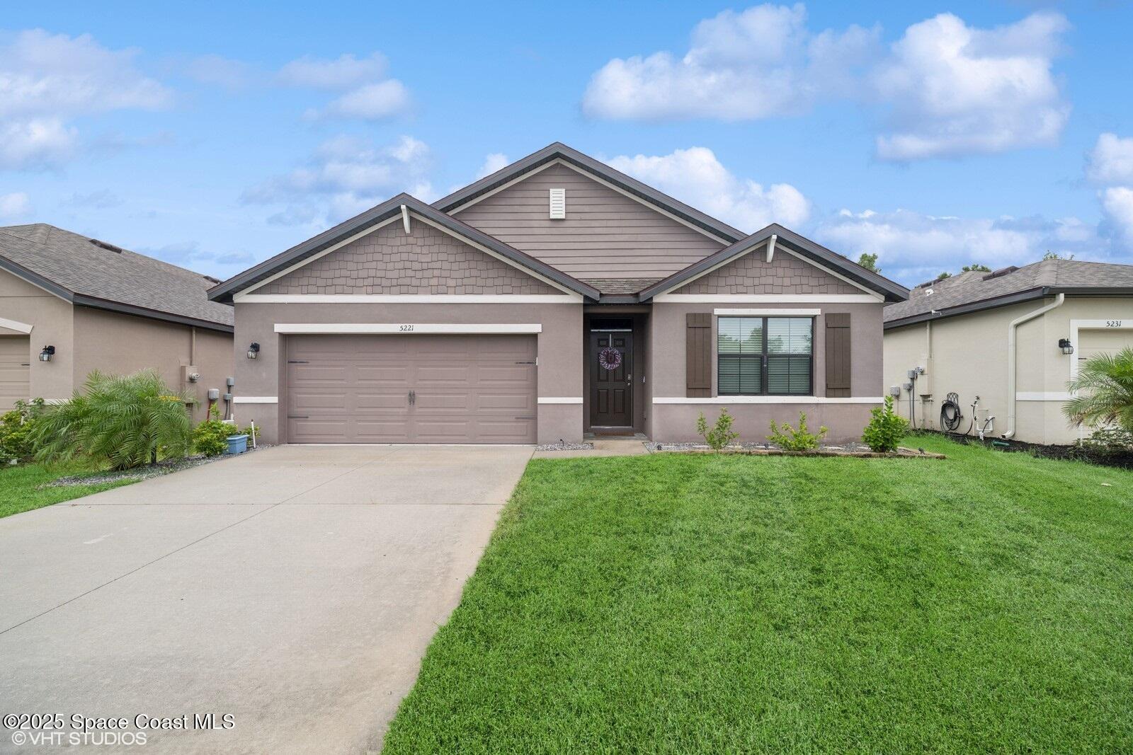 5221 Talbot Boulevard Cocoa, FL 32926 - Photo 1 of 32 a front view of a house with a yard and garage