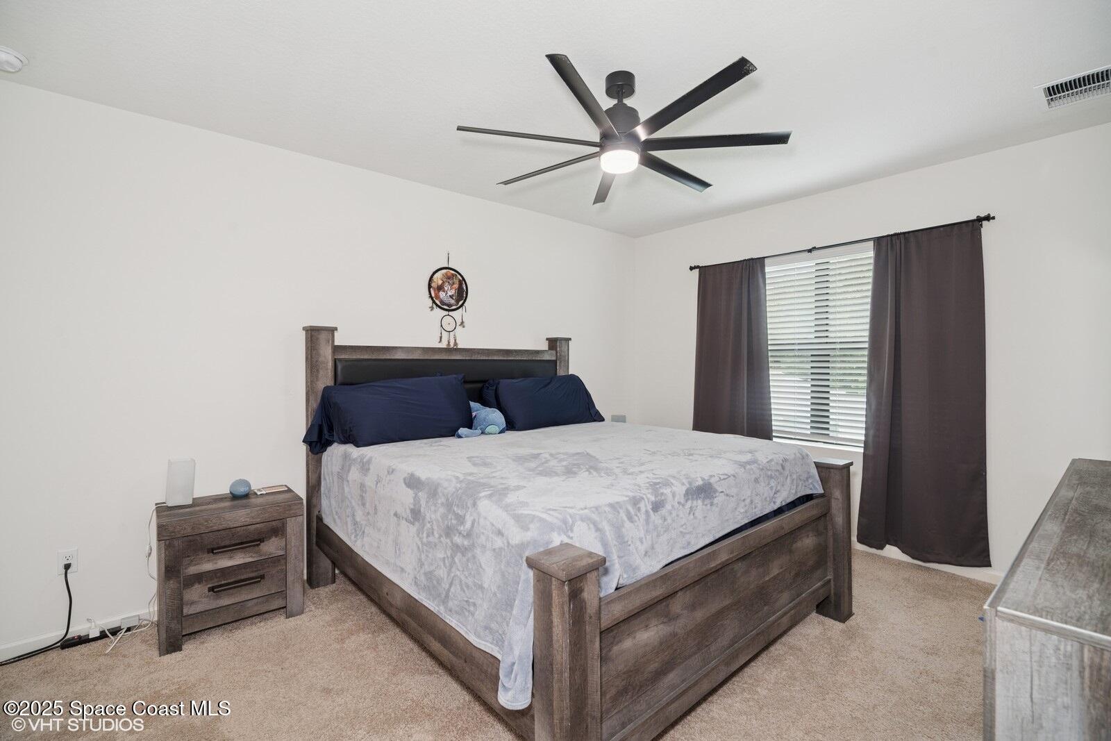 5221 Talbot Boulevard Cocoa, FL 32926 - Photo 15 of 32 a bedroom with a bed and a chandelier