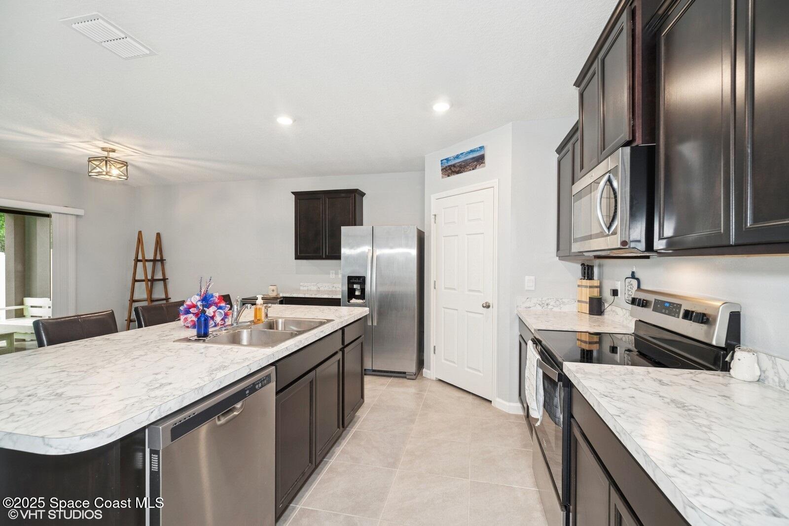 5221 Talbot Boulevard Cocoa, FL 32926 - Photo 6 of 32 a kitchen with stainless steel appliances granite countertop a sink stove and refrigerator