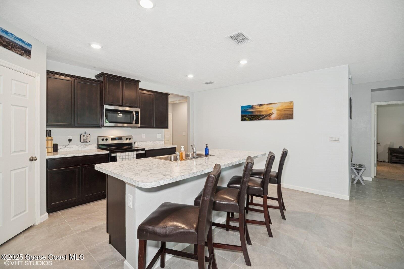 5221 Talbot Boulevard Cocoa, FL 32926 - Photo 8 of 32 a kitchen with a table chairs refrigerator and microwave