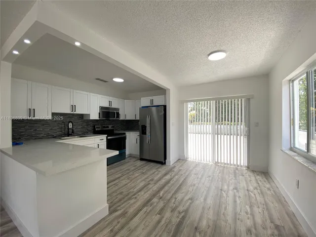 a kitchen with stainless steel appliances a refrigerator and a stove top oven
