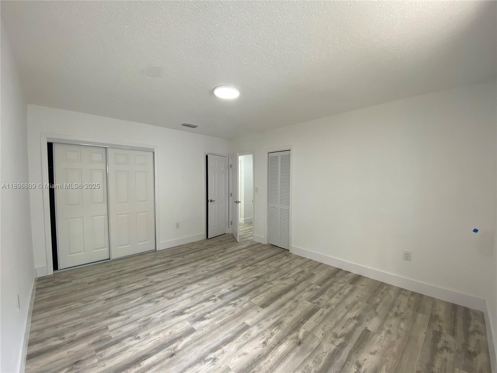 46 Northwest 44th Street, Unit 46 Miami, FL 33127 - Photo 6 of 16 a view of an empty room and wooden floor