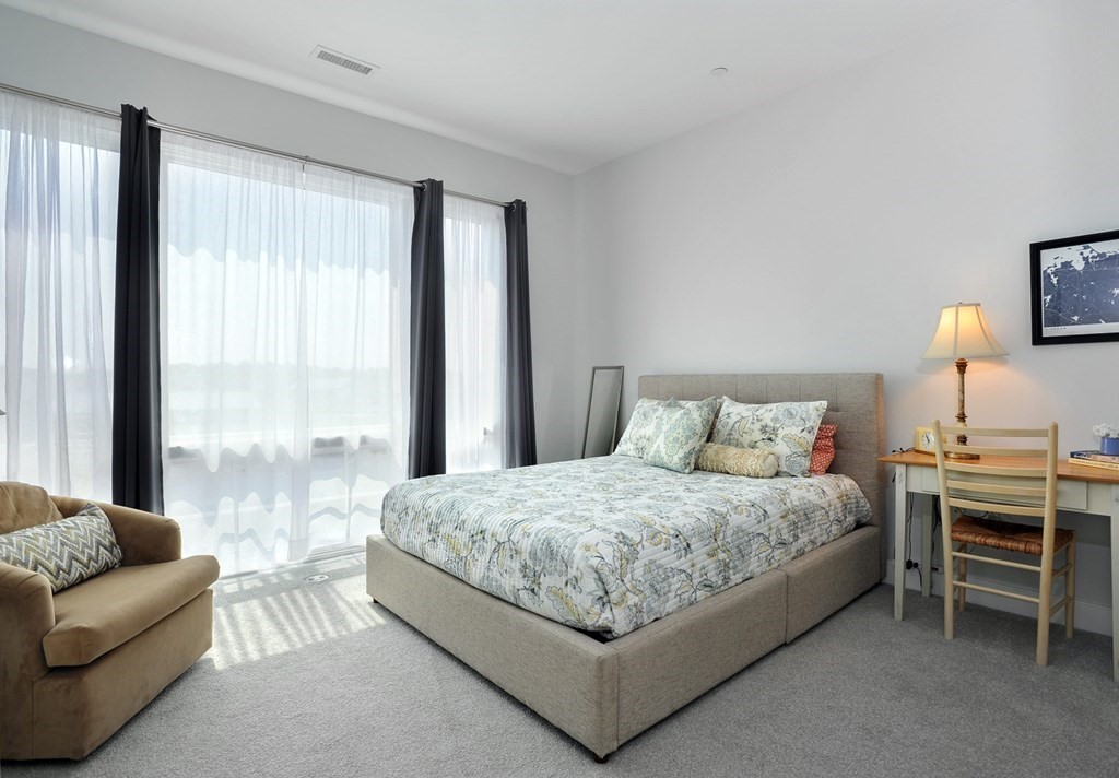 10 Shipyard Drive, Unit 401 Hingham, MA 02043 - Photo 14 of 24 a bedroom with a bed and a couch next to a window