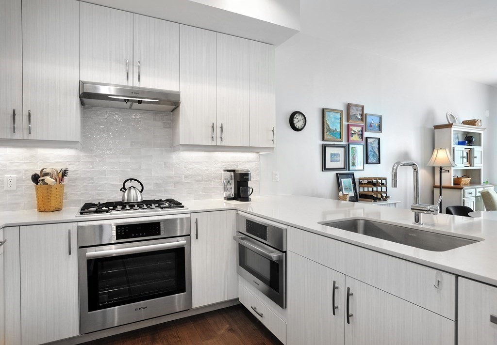 10 Shipyard Drive, Unit 401 Hingham, MA 02043 - Photo 5 of 24 a kitchen with cabinets stainless steel appliances and a sink
