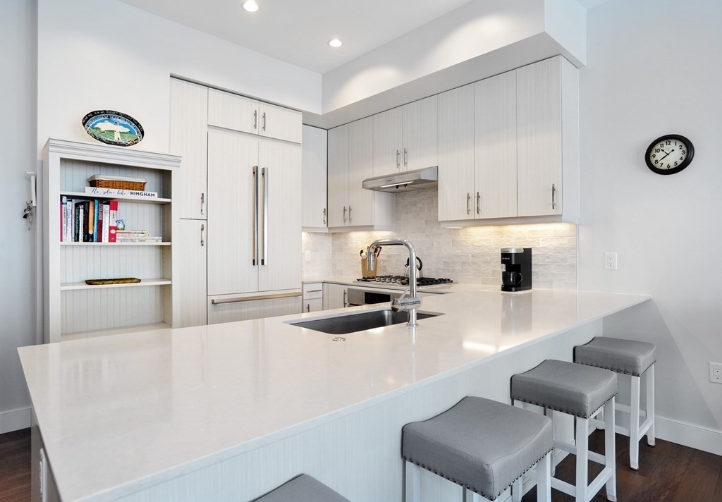 10 Shipyard Drive, Unit 401 Hingham, MA 02043 - Photo 6 of 24 a kitchen with granite countertop a sink a stove and a refrigerator