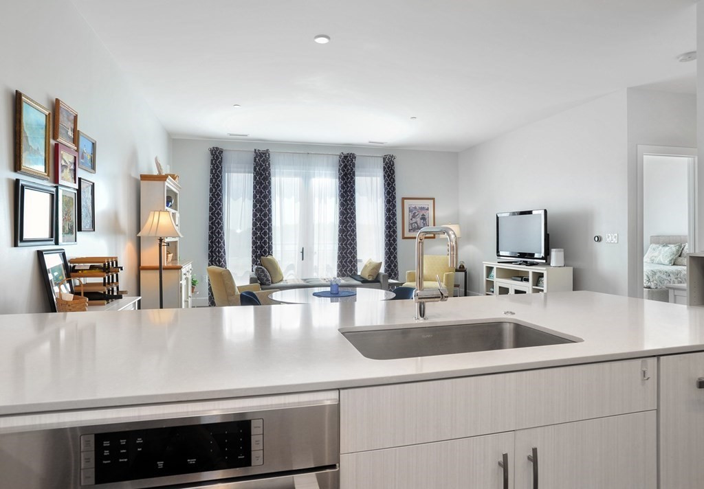 10 Shipyard Drive, Unit 401 Hingham, MA 02043 - Photo 7 of 24 a kitchen with stainless steel appliances granite countertop a sink and a refrigerator