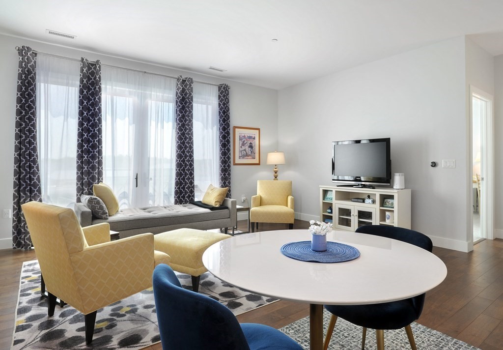 10 Shipyard Drive, Unit 401 Hingham, MA 02043 - Photo 9 of 24 a living room with furniture a flat screen tv and a large window