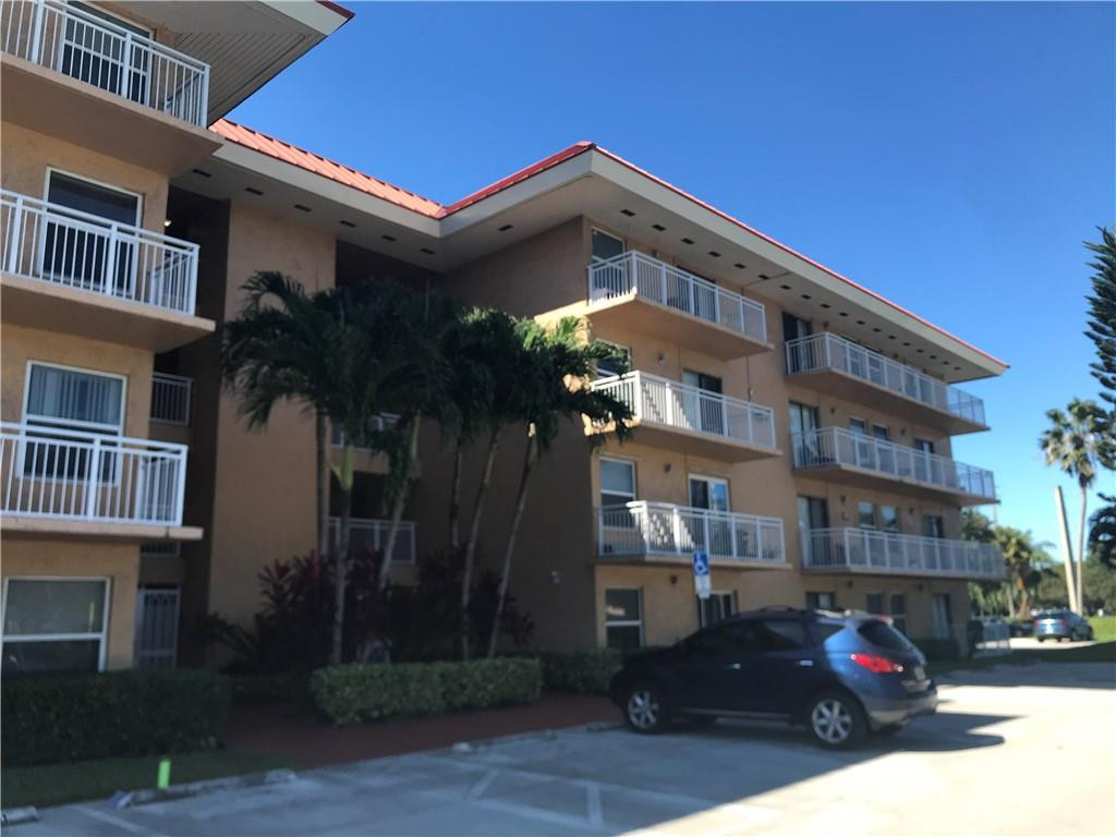 405 South Pine Island Road, Unit 401D Plantation, FL 33324 - Photo 2 of 13 a front view of a residential apartment building with a yard