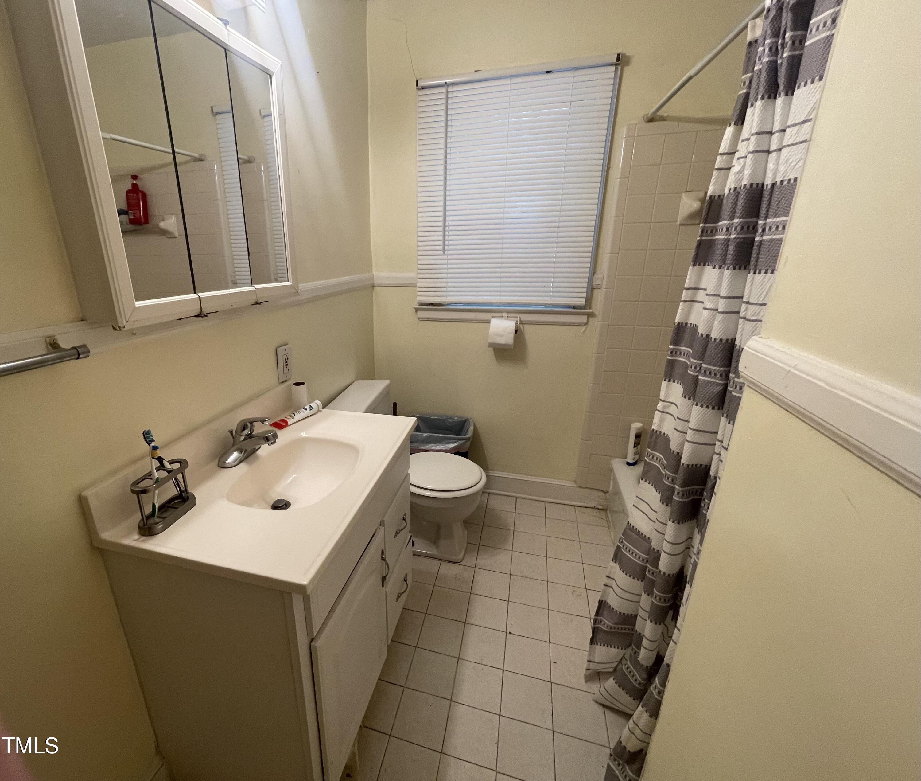 2204 Guess Road Durham, NC 27705 - Photo 13 of 15 a bathroom with a sink and mirror with toilet