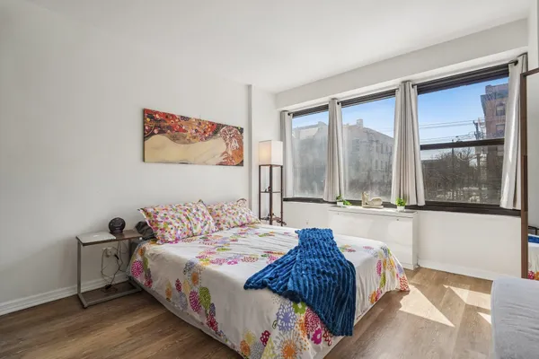 a bedroom with a bed and a large window