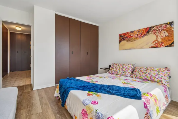 a bedroom with a bed and a painting on the wall