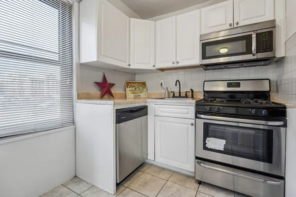 a kitchen with stainless steel appliances granite countertop a stove microwave and cabinets