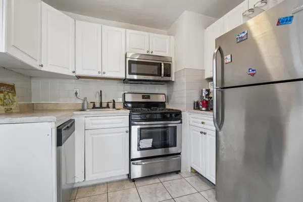 a kitchen with stainless steel appliances granite countertop a refrigerator sink and cabinets