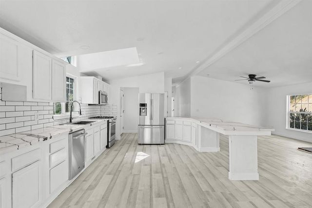 an empty room with fireplace and windows