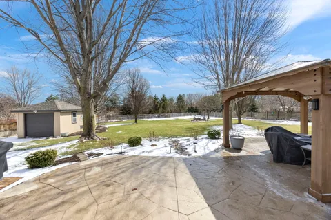 a view of a house with backyard and a large tree