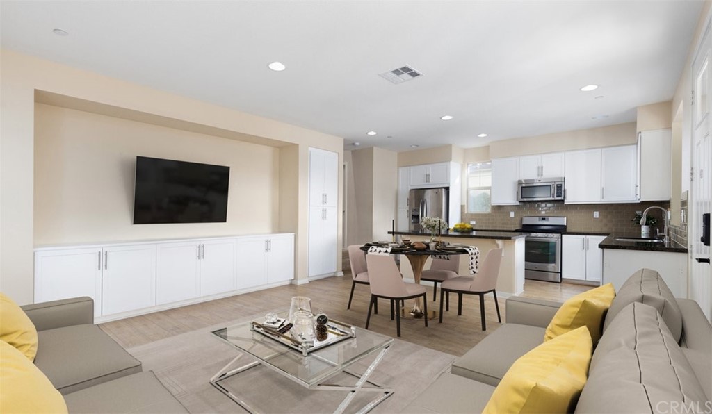 2 Adelfa Street Rancho Mission Viejo, CA 92694 - Photo 5 of 56 a living room with furniture a flat screen tv and kitchen view