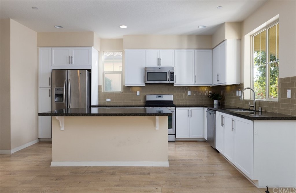 2 Adelfa Street Rancho Mission Viejo, CA 92694 - Photo 8 of 56 a kitchen with stainless steel appliances granite countertop a stove a sink a refrigerator a microwave and cabinets