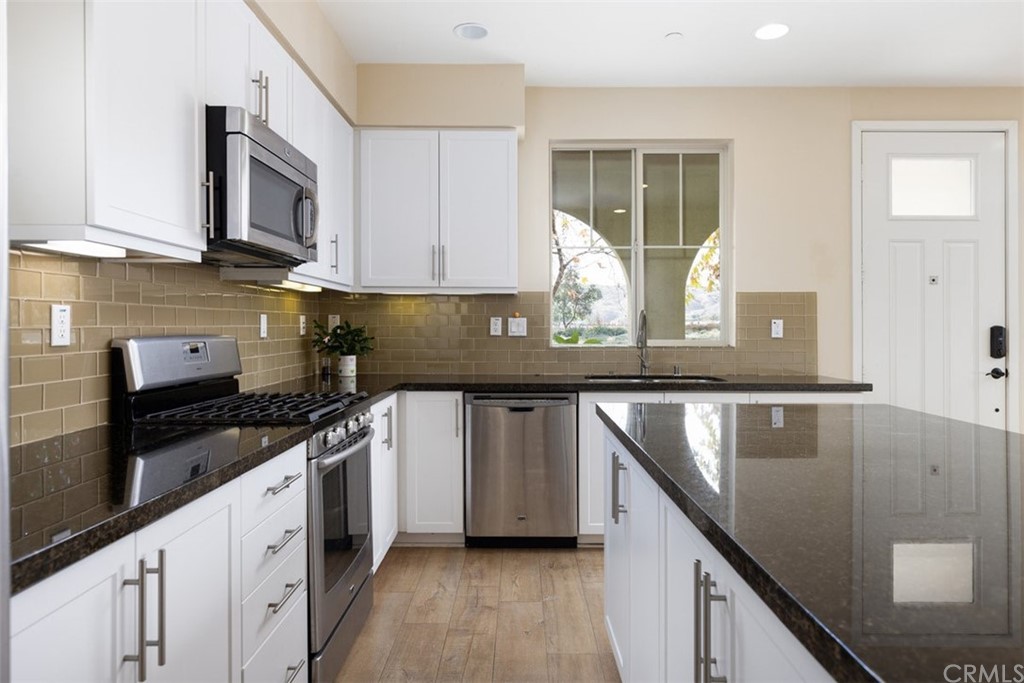 2 Adelfa Street Rancho Mission Viejo, CA 92694 - Photo 9 of 56 a kitchen with stainless steel appliances granite countertop a sink a stove and cabinets