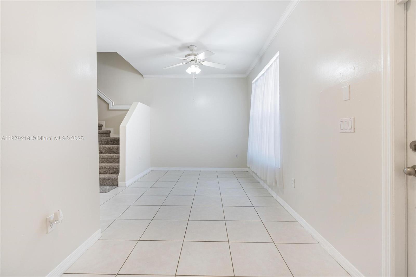 9135 Southwest 203rd Terrace Cutler Bay, FL 33189 - Photo 11 of 27 a view of an empty room with stairs and chandelier fan