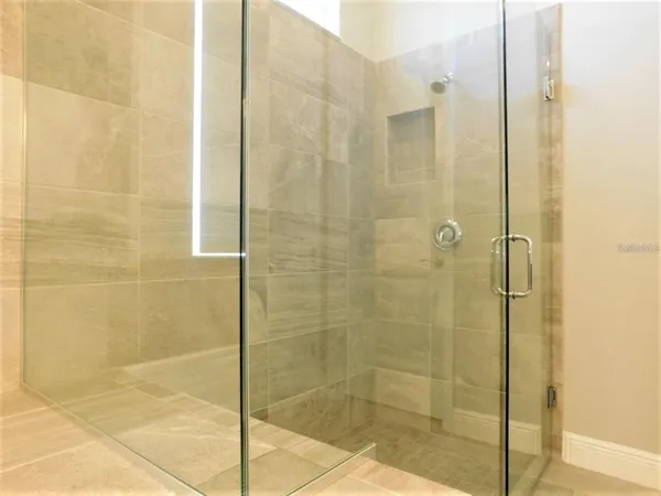 a living room with stainless steel appliances furniture and a flat screen tv