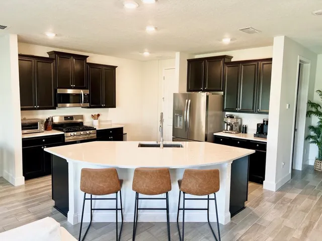 a large kitchen with kitchen island a dining table and chairs