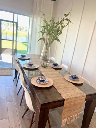 a dining room with furniture and a potted plant