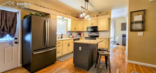 a kitchen with stainless steel appliances granite countertop a refrigerator a oven a sink and a refrigerator