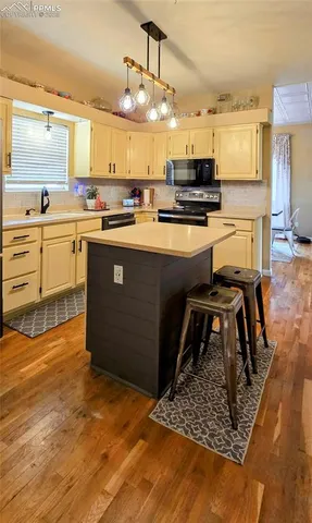 a kitchen with stainless steel appliances kitchen island granite countertop a stove a sink and a microwave