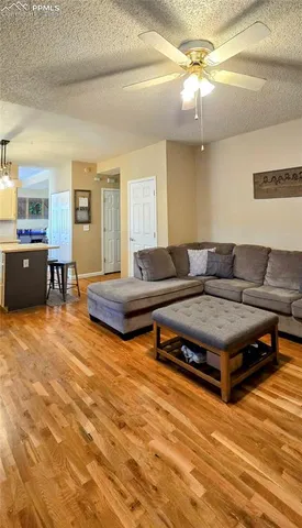 a living room with furniture and a wooden floor