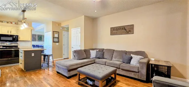 a living room with furniture kitchen view and a window