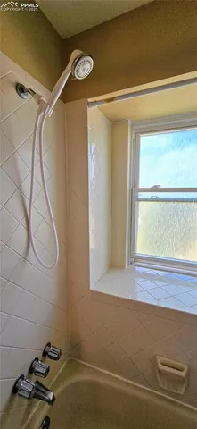 a bathroom with a window and a shower
