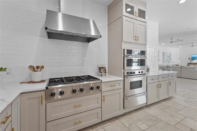 a spacious bathroom with a granite countertop double vanity sink a mirror and a bathtub