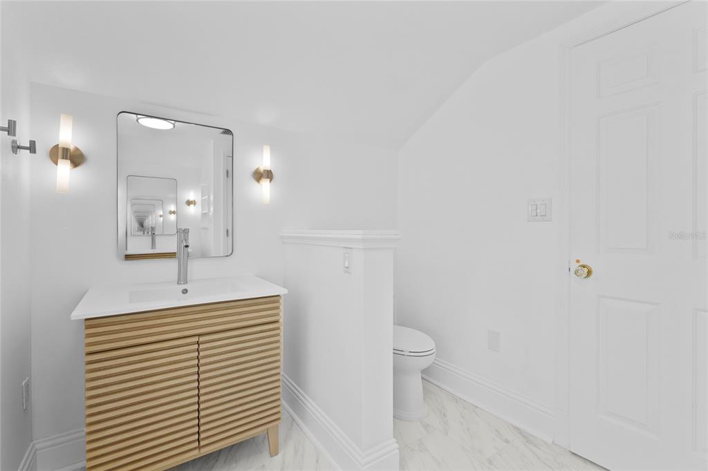 1826 Boyce Street Sarasota, FL 34239 - Photo 62 of 98 a bathroom with a sink a toilet and mirror