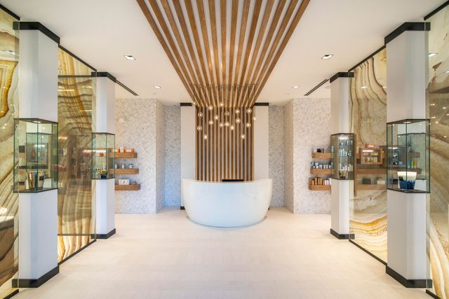a view of a hallway with dining area and chandelier