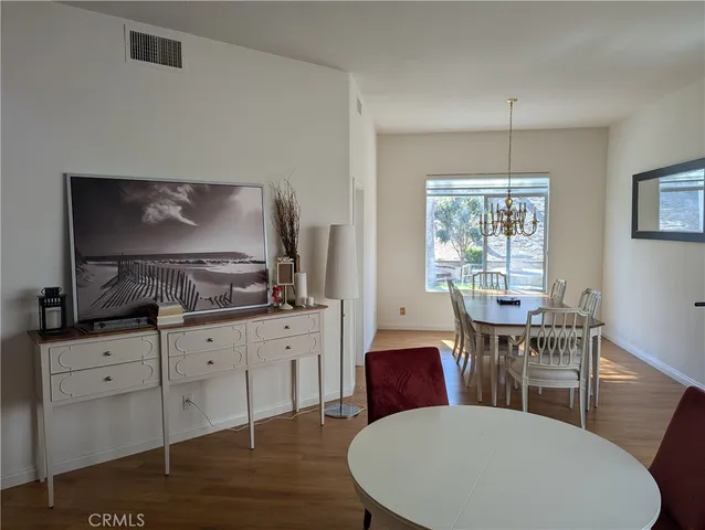 a kitchen with granite countertop a dining table chairs and white cabinets