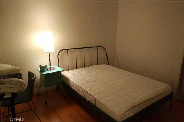 a bed sitting in a bedroom next to a window with chair
