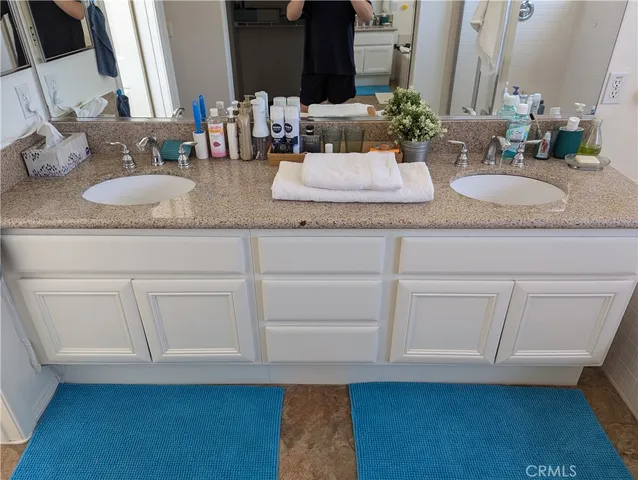 a bathroom with granite countertop a sink and a mirror