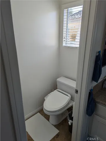 a white toilet sitting next to a window