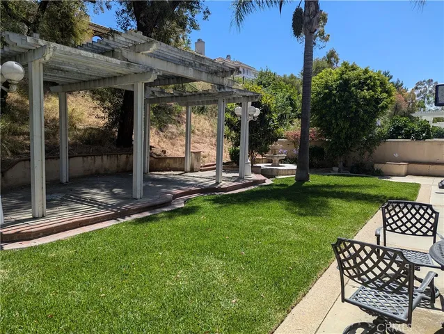 a view of a chair and table in backyard of the house