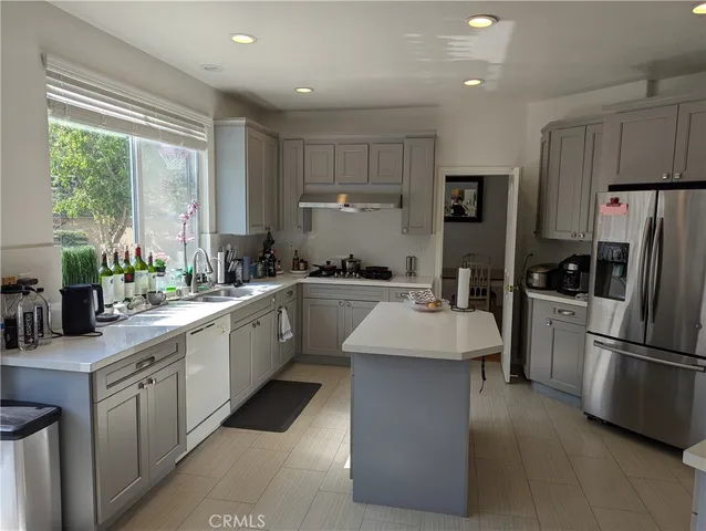 a kitchen with a sink stainless steel appliances and windows