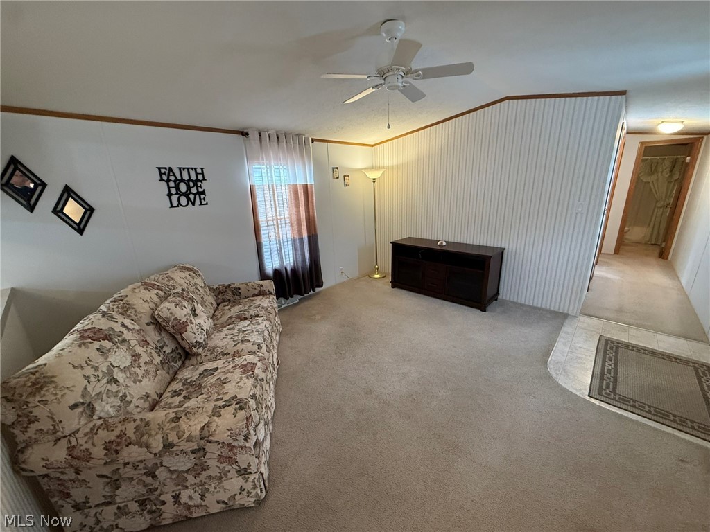 2933 Rabbit Drive Dennison, OH 44621 - Photo 11 of 28 Living area featuring ornamental molding, carpet flooring, a ceiling fan, and lofted ceiling