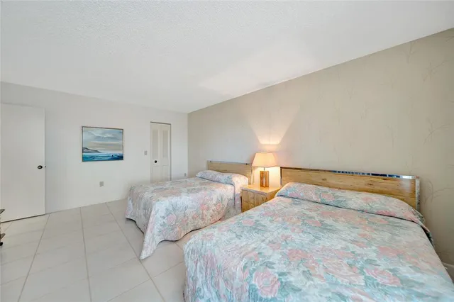 a bedroom with two beds and a lamp on dresser