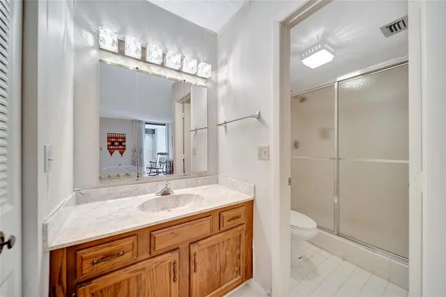 a bathroom with a sink a toilet a mirror and shower