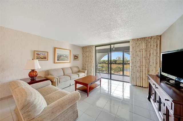 a living room with furniture a flat screen tv and a floor to ceiling window
